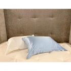 Beige sengegavl med silkepute i hvitt og lys blått